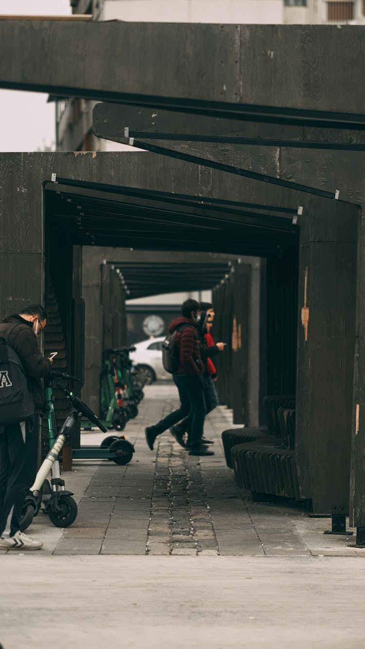 People Crossing Under Arch Bridge