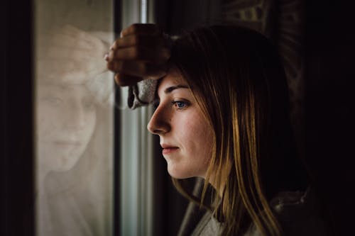 Vrouw Die Op Glasvenster Leunt