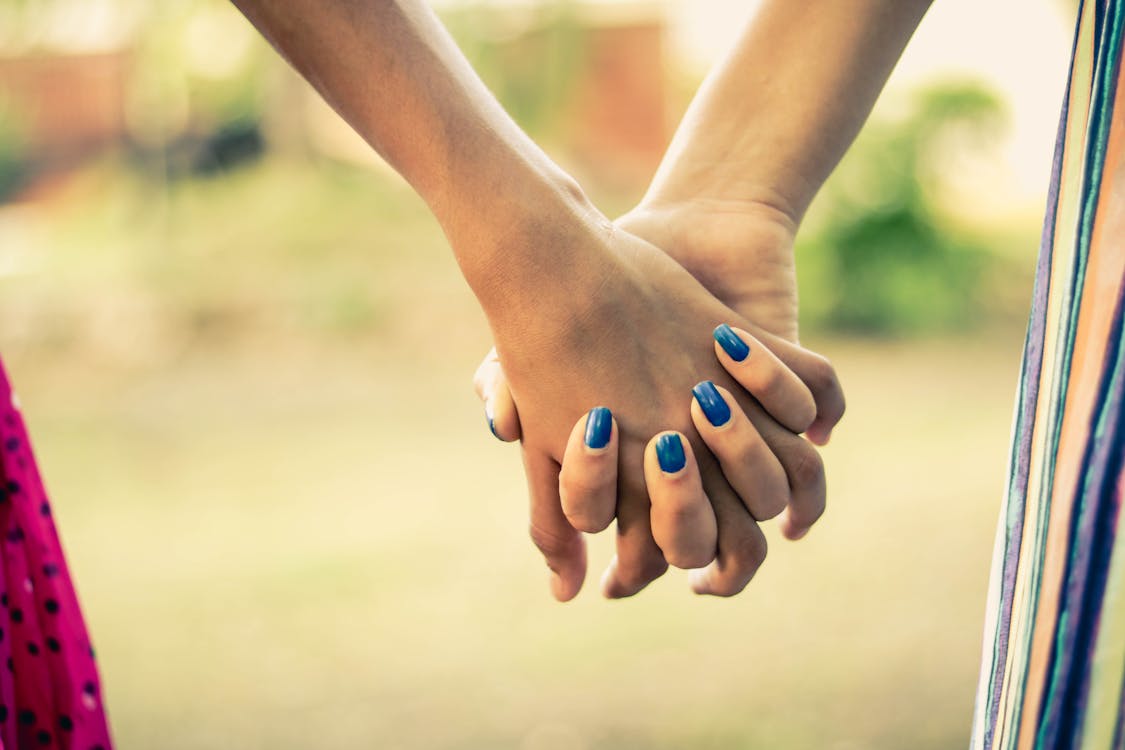 Free Shallow Focus Photography Of Two Person Holding Hands Stock Photo