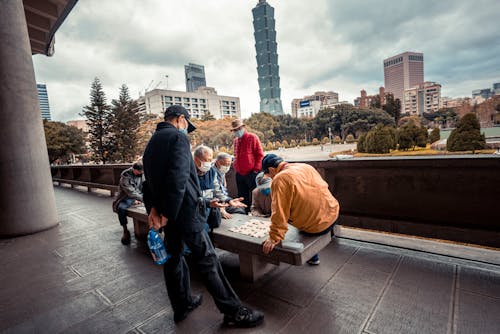 Elderly Men Playing a Board Game on a Concrete Bench