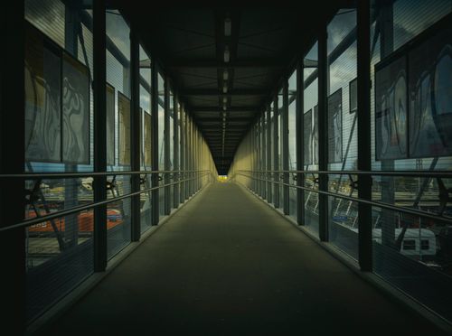 Free A contemporary indoor bridge with metal railings and window views. Stock Photo
