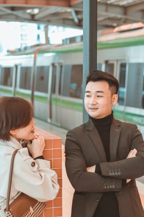 A Man and a Woman Waiting at a Train Station 