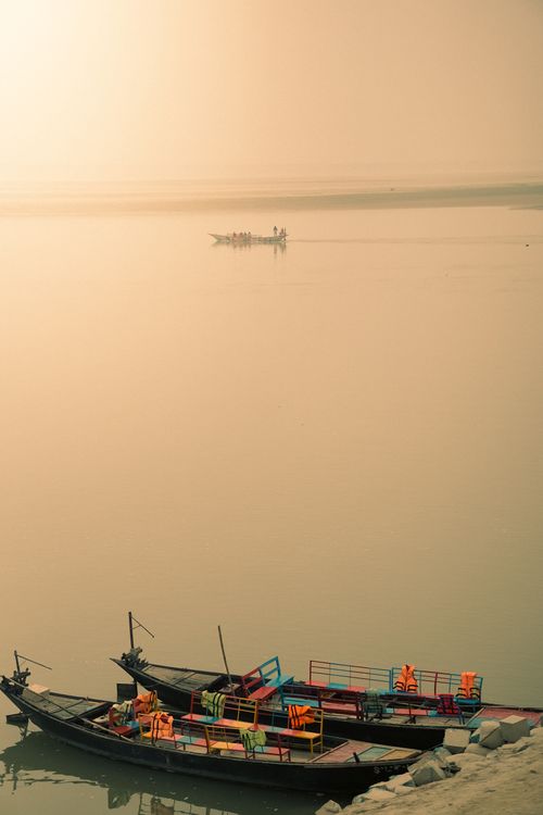 Free Colorful wooden boats docked on a misty river in Bangladesh with serene morning ambiance. Stock Photo
