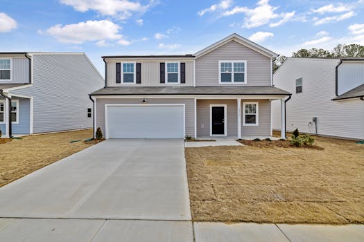 A modern suburban home with a driveway and front lawn, showcasing residential real estate.