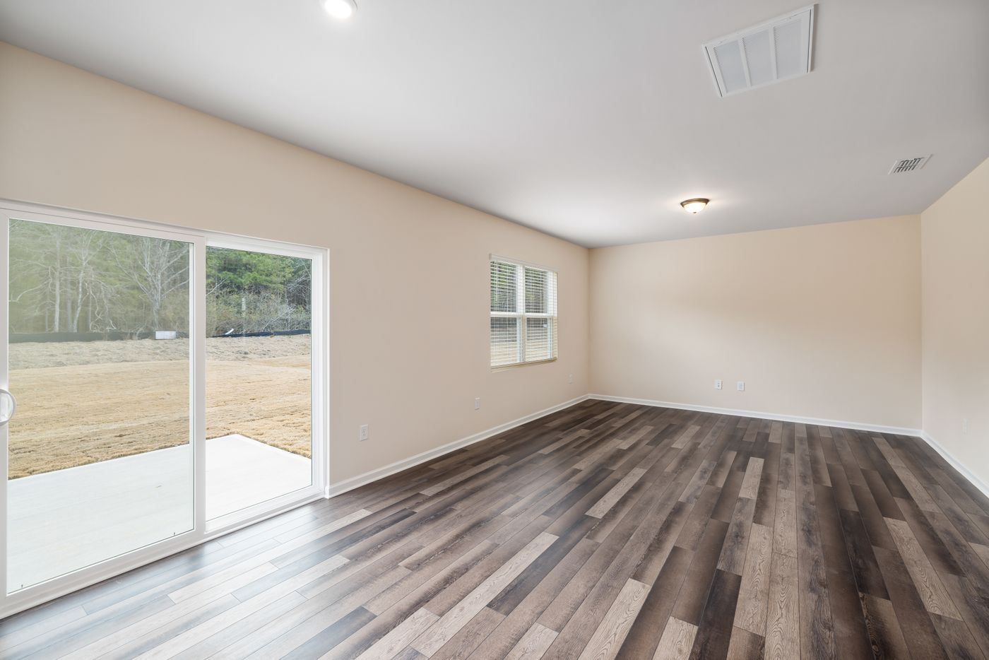 Spacious bright room with wood parquet flooring and a large sliding door