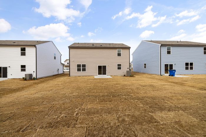 Rear elevation of a home with a wide lawn, photo by Curtis Adams on Pexels