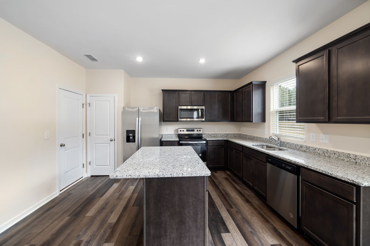 forest-green-kitchen-cabinets Spacious modern kitchen with granite countertops and dark wood cabinetry