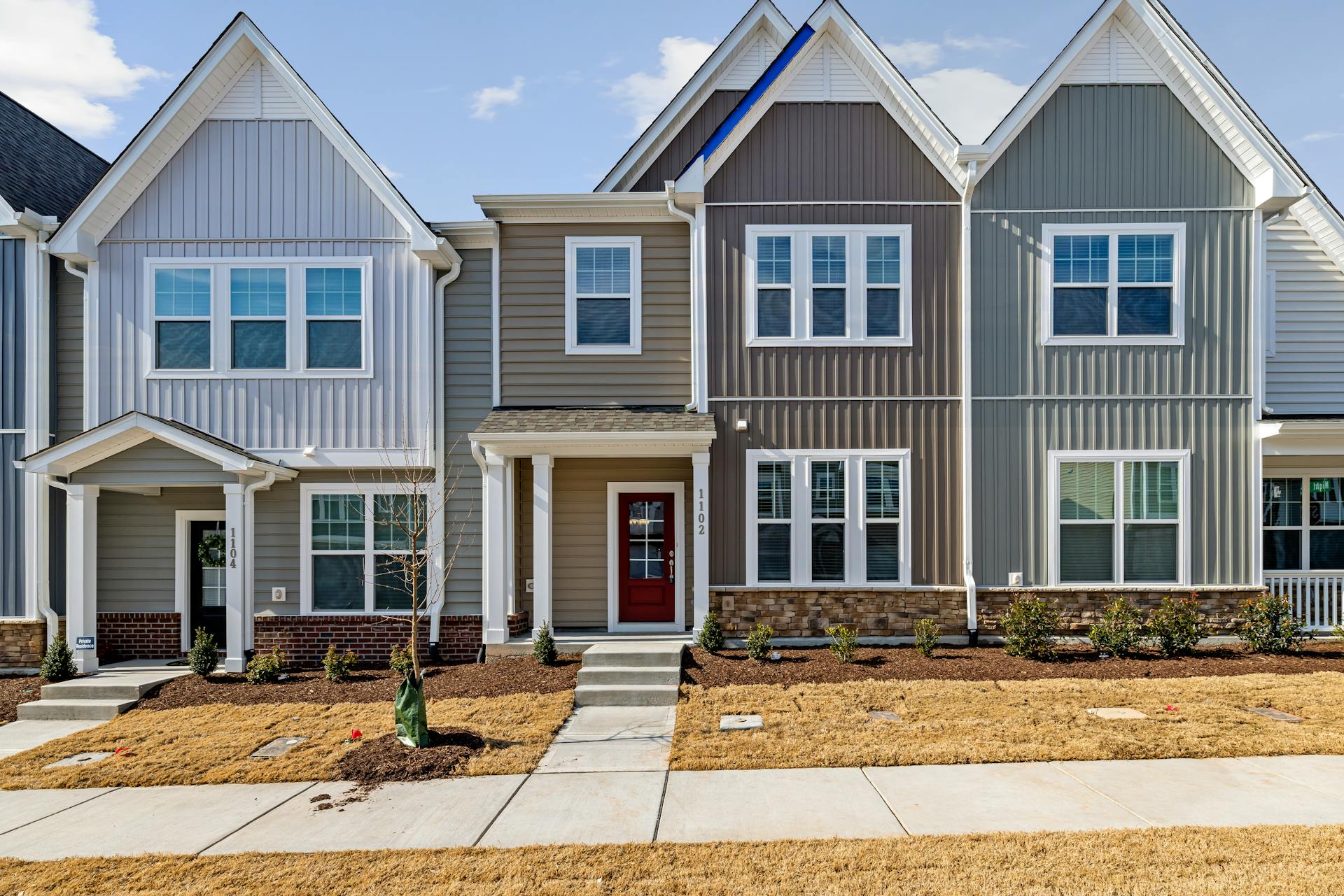 Charming modern townhouses in a suburban residential area with neat landscaping.