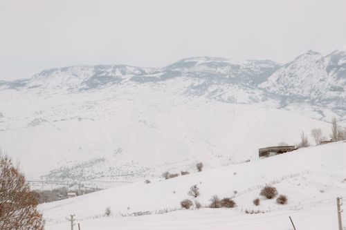 Free Peaceful snowy landscape showcasing rugged mountains under a winter sky. Stock Photo