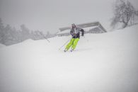 Person in Red Jacket and Black Pants Riding Ski Blades on Snow Covered Ground