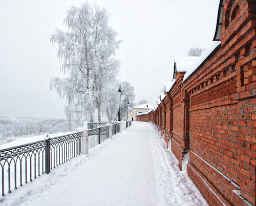 Road in Snow near Brick Fence
