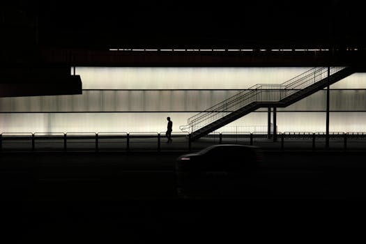 Nighttime scene in Seoul featuring a silhouette of a pedestrian against an illuminated wall.