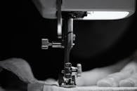 Person in White Shirt Using Sewing Machine