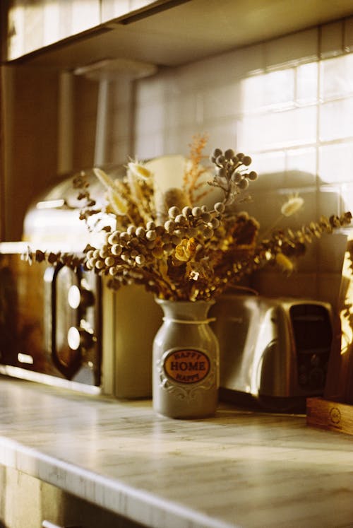 Golden Flowers in Ceramic Vase on Kitchen Counter