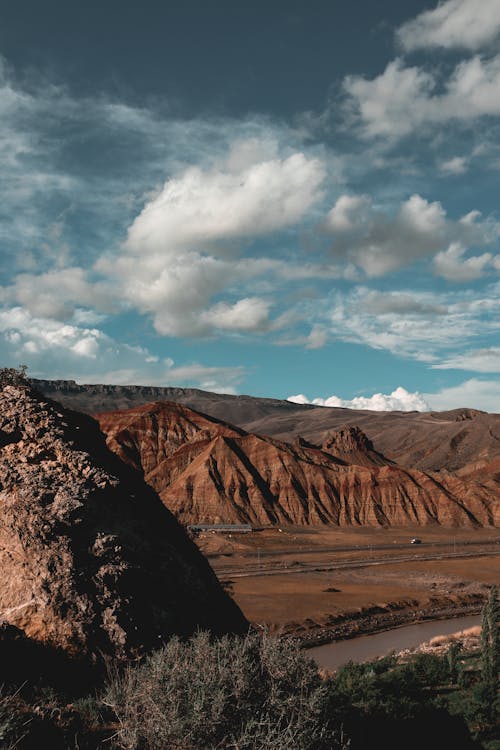 Brown Mountains Under White Clouds and Blue Sky