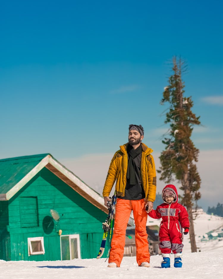 Father And Son Skiing In Mountains 