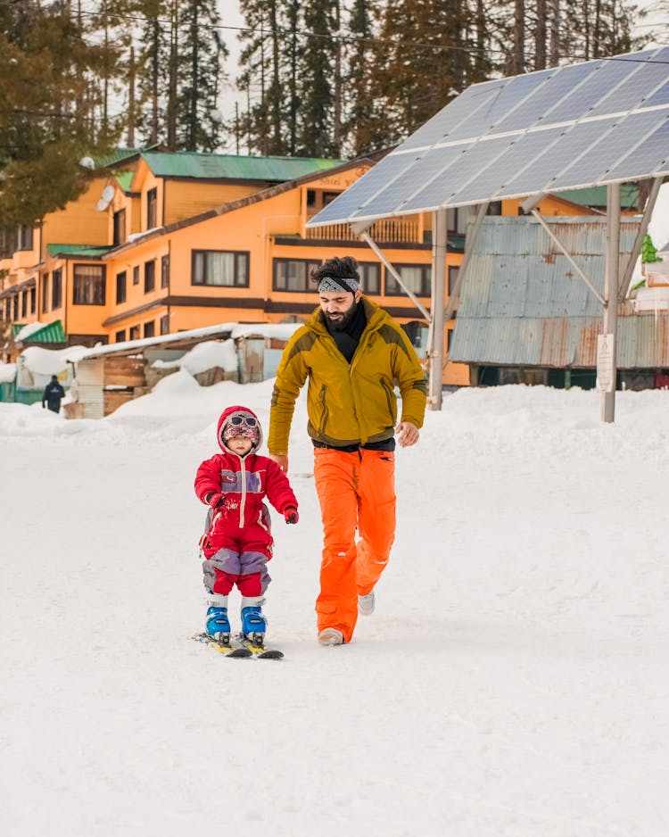 A Man Following His Child While Skiing