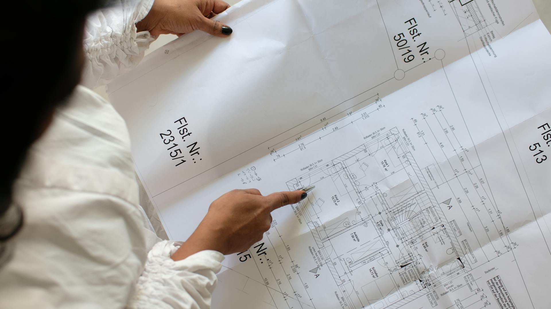 A person reviewing architectural blueprints with focus on planning and design.