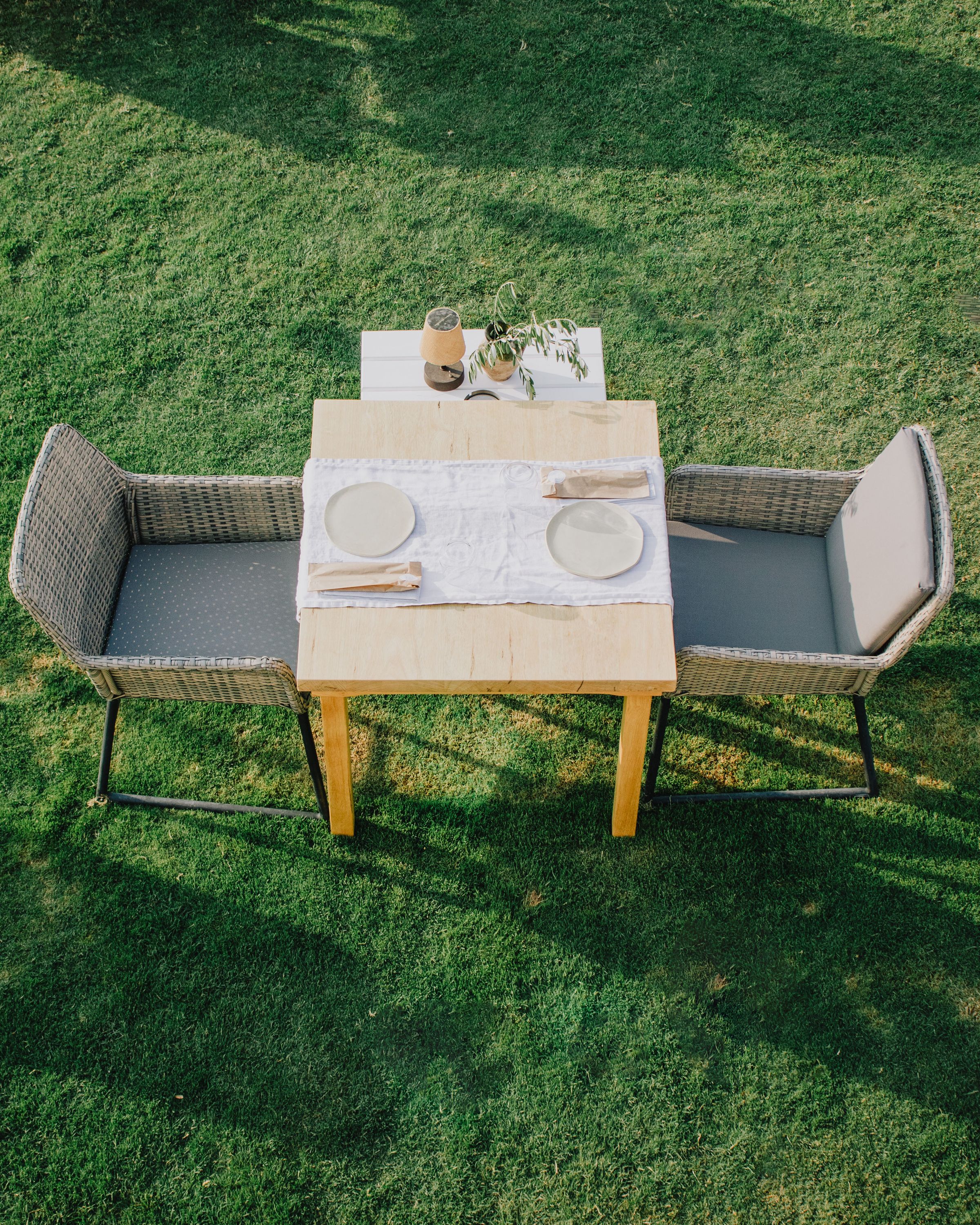 An outdoor wooden table set for a long evening meal