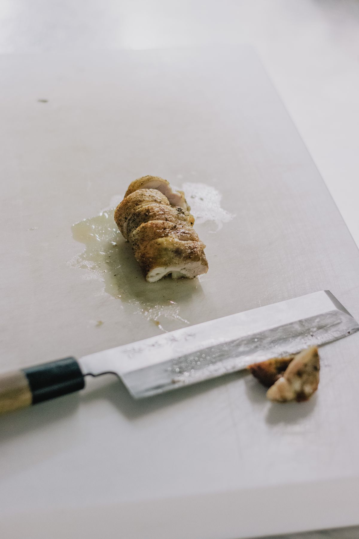 도마 위에서 칼로 슬라이스한 닭가슴살과 셰프 나이프