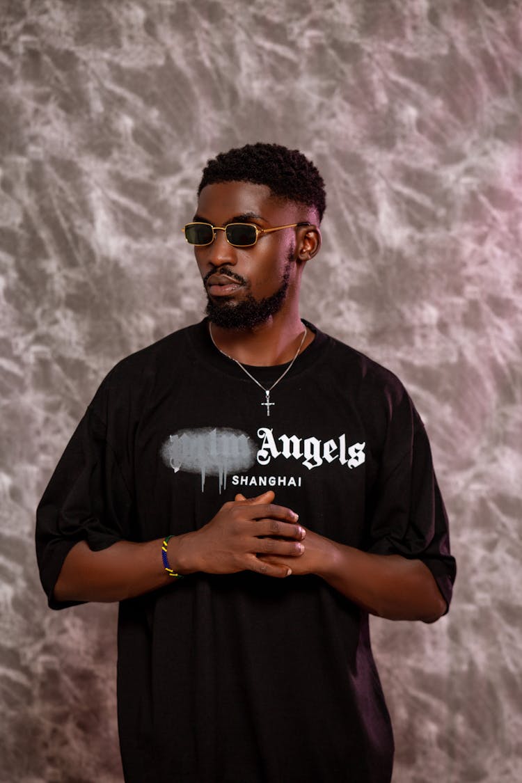 Man In Sunglasses In Black T-shirt Standing With Folded Hands