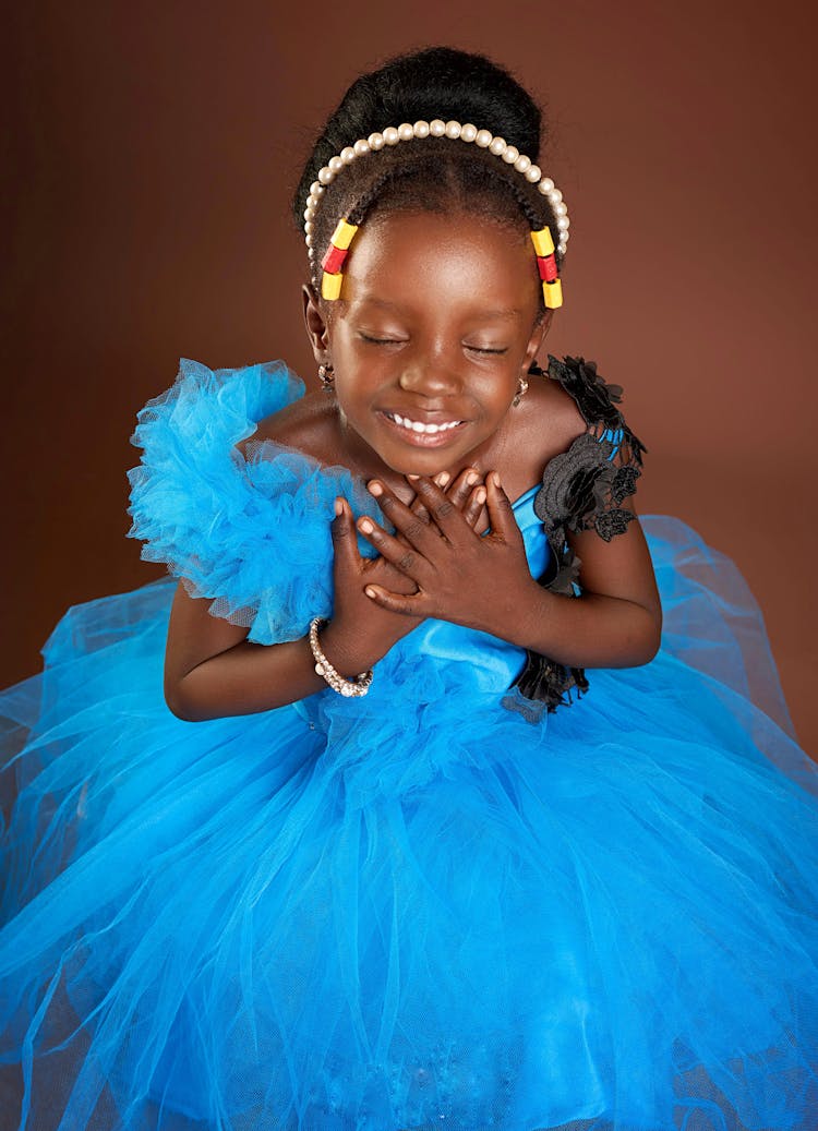 Cute Little Girl Dressed In Blue Tulle Dress On Brown Background