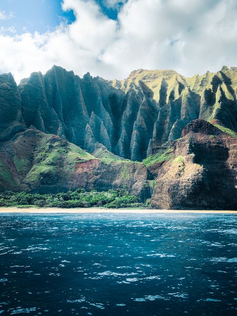 Rocky cliffs meeting the ocean along Kauai's Napali Coast