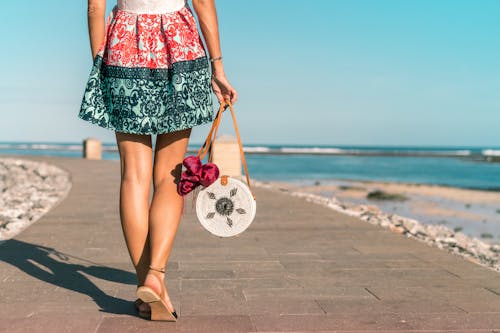 Woman Wearing Mini Skirt Holding Round Wicker Bag