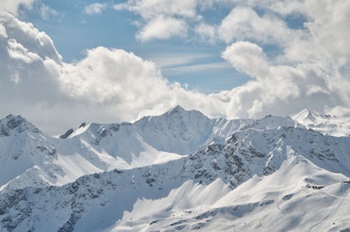 Snow Covered Mountains Under White Clouds