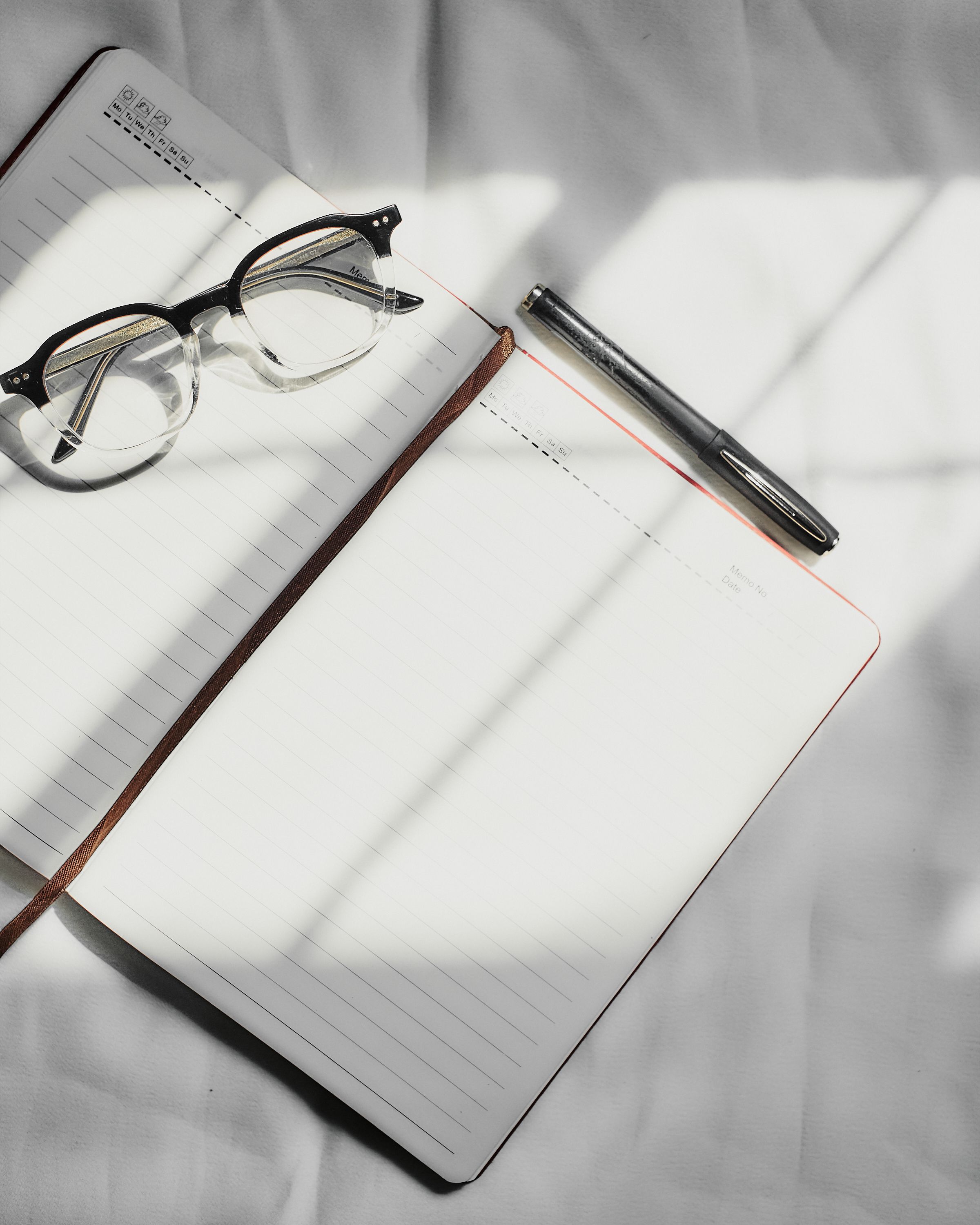 Close-Up Photography of Notebook Near Pens · Free Stock Photo