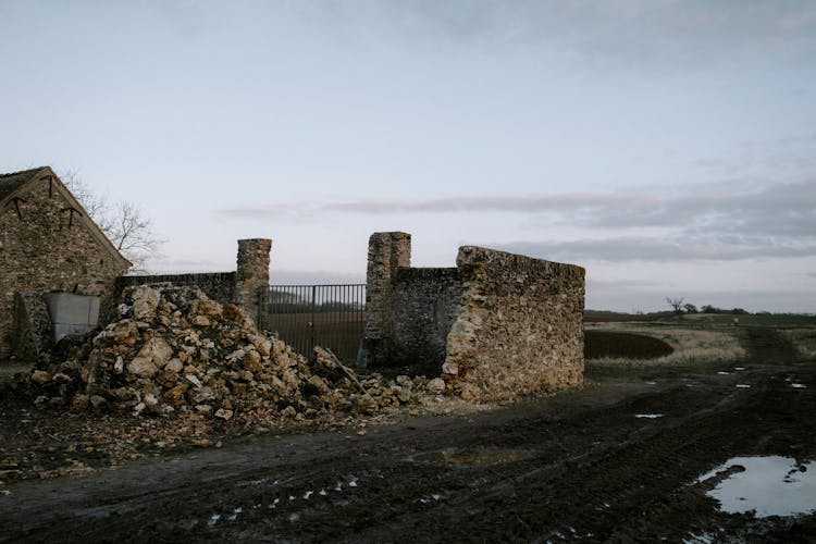 Abandoned Broken Stone Wall On Muddy Ground