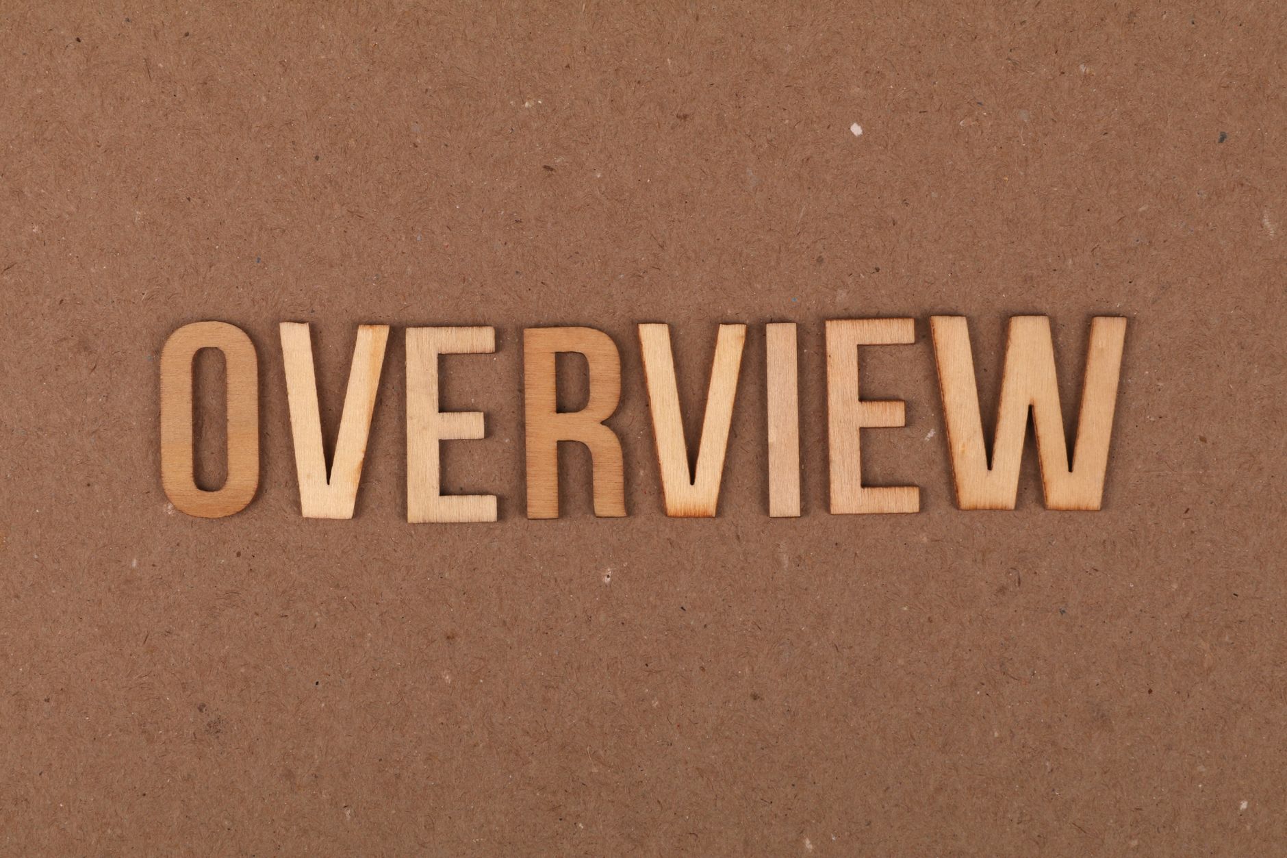 High-resolution image of wooden letters spelling 'OVERVIEW' on a brown background.