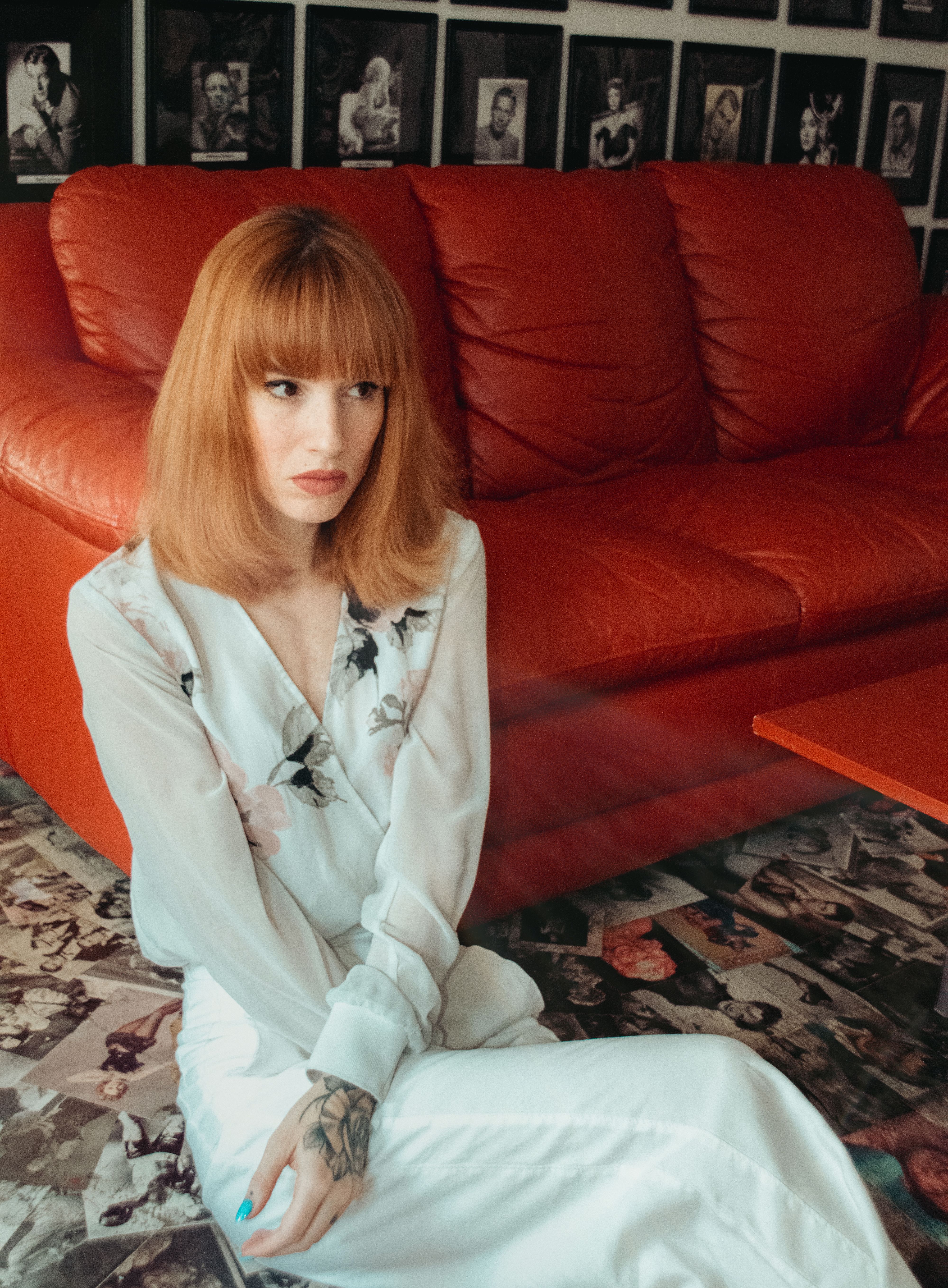 Woman in White Long Sleeves Sitting on Red Leather Couch · Free Stock Photo