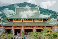 这座拥有绿色屋顶的美丽传统亚洲寺庙，坐落在山区背景之中