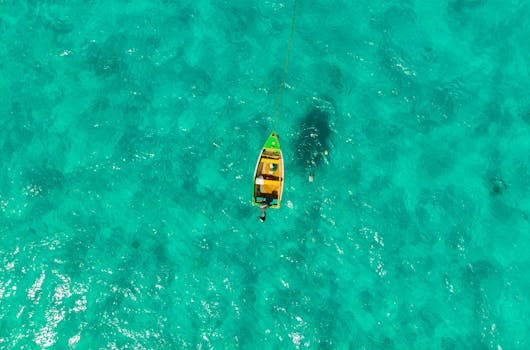 Drone capture of a lone boat sailing in the crystalline turquoise waters near Barbados.