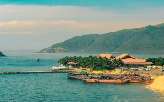 宁静的沿海景观，以船只、度假村和郁郁葱葱的青山为特色