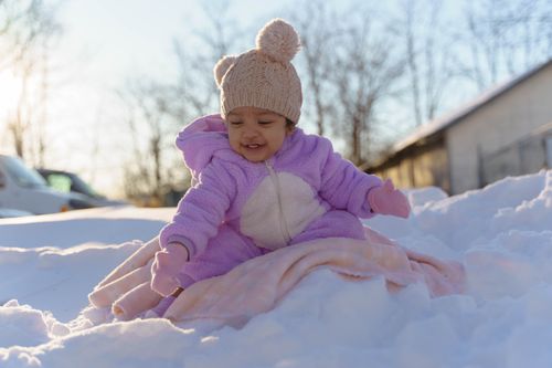 Free Cute toddler in a beanie enjoying the frosty outdoors in winter attire. Stock Photo