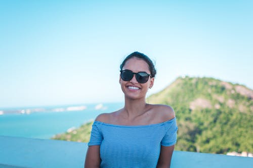 Free Smiling Woman Wearing Grey Striped Off-shoulder Top And Black Sunglasses Stock Photo