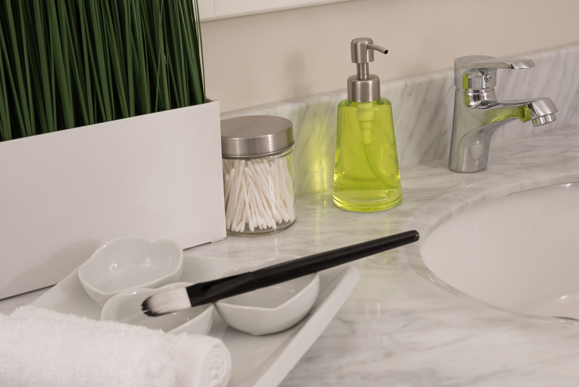 Close-up of a bathroom vanity featuring elegant decor, including soap dispenser and decorative plants.