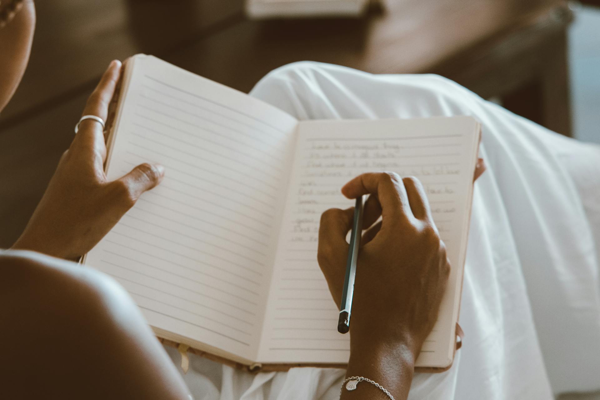 A Person Writing on a Notebook