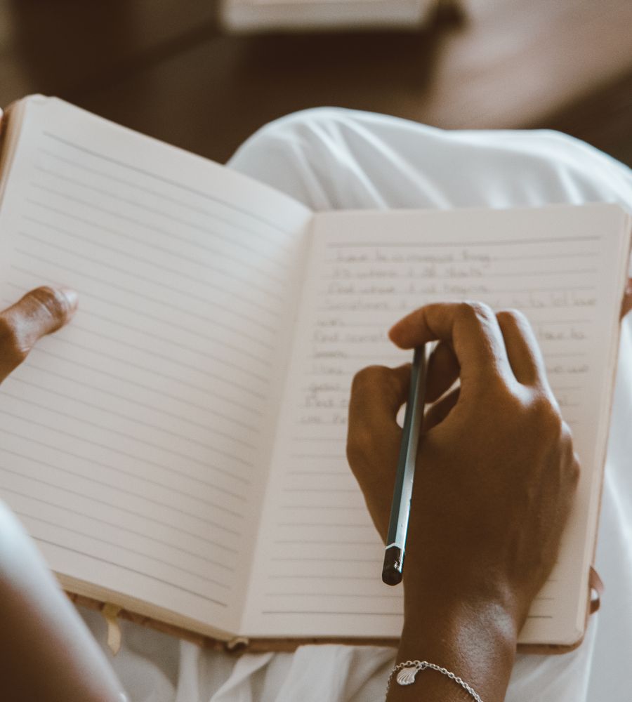 Hands writing in an open journal
