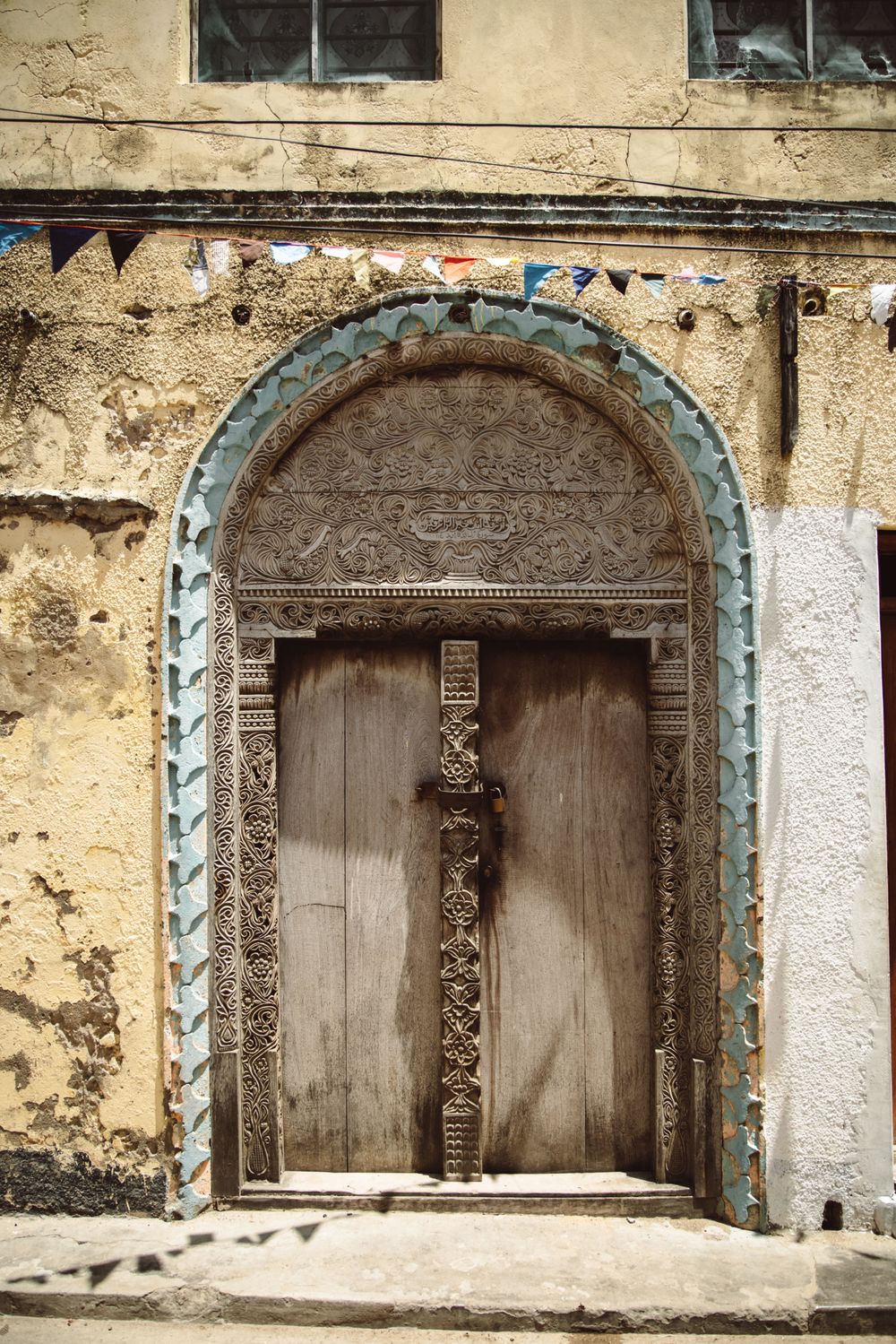 Puerta de madera tallada en arco en una calle de Stone Town, Zanzíbar