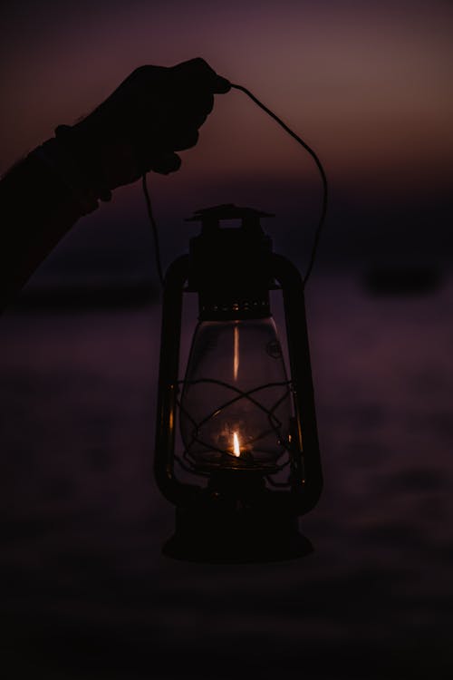 Free A Person Holding a Lantern Lamp Stock Photo