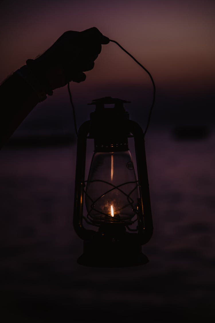 A Person Holding A Lantern Lamp