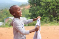 在一个阳光明媚的日子里，快乐的小男孩布隆迪吉特加在外面笑着玩耍