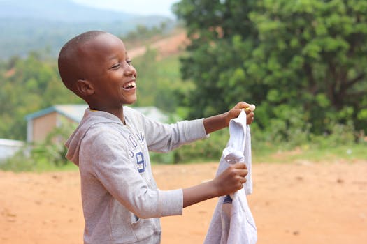 在一个阳光明媚的日子里，快乐的小男孩布隆迪吉特加在外面笑着玩耍