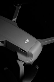 Detailed close-up of a sleek grey drone on a black background, showcasing modern technology.