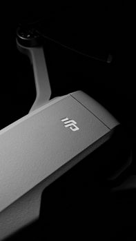 A close-up black and white image of a drone in a studio with a textured finish.