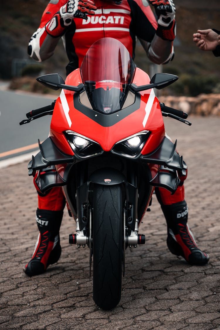 Man Wearing A Racing Suit Sitting On A Motorcycle