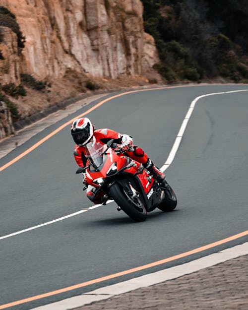 Free A Man Riding Red Sports Bike on the Road Stock Photo